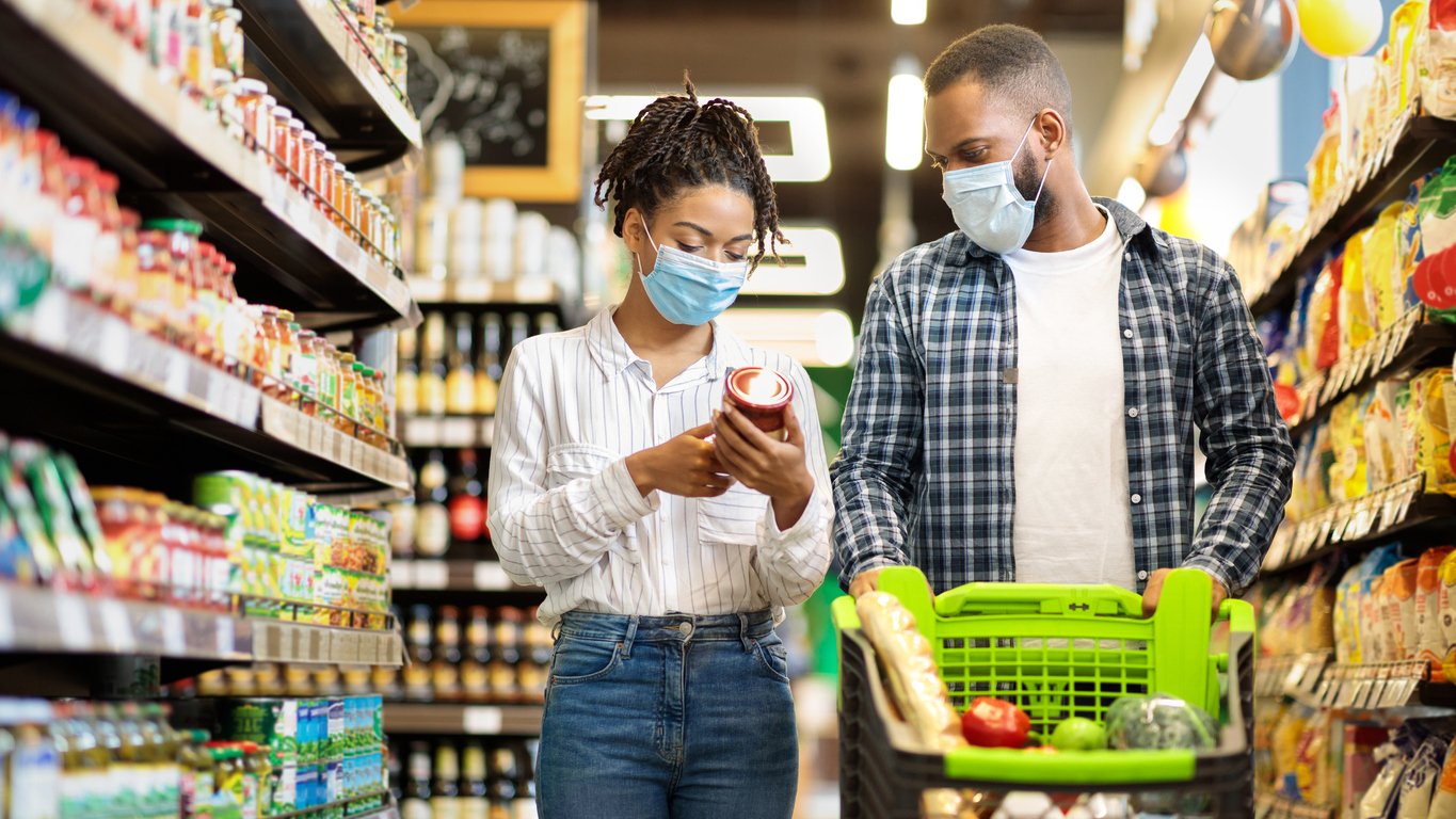 Couple shopping in a grocery store with masks on