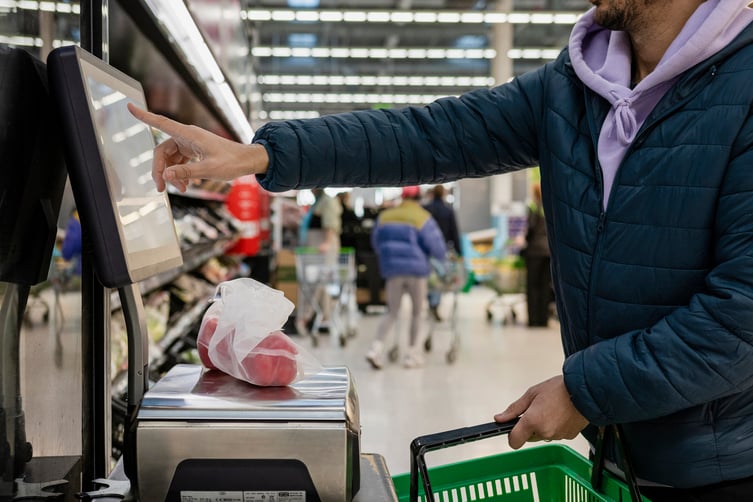 man-purchasing-tomatoes-self-checkout