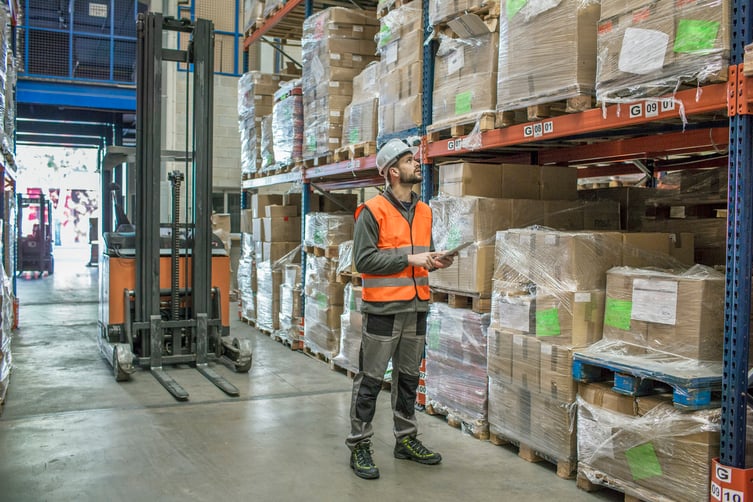 man-tracking-warehouse-inventory-with-tablet