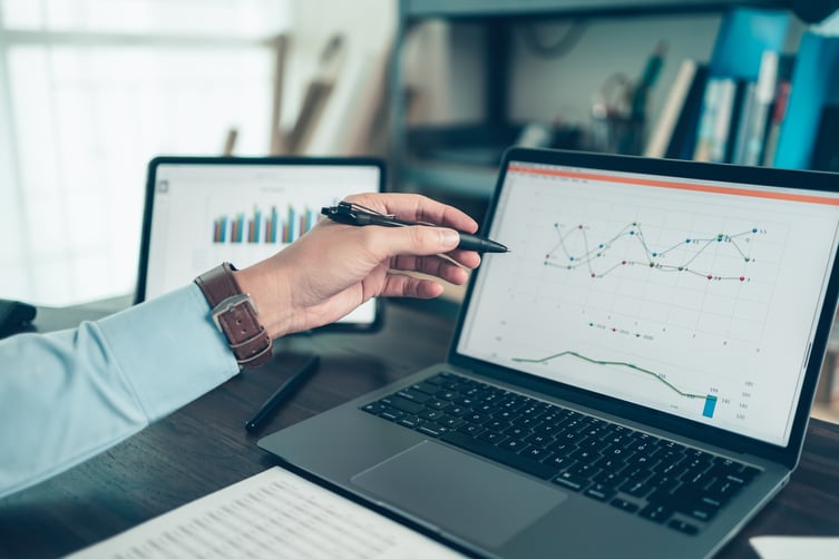 woman-examining-data-charts-on-laptop