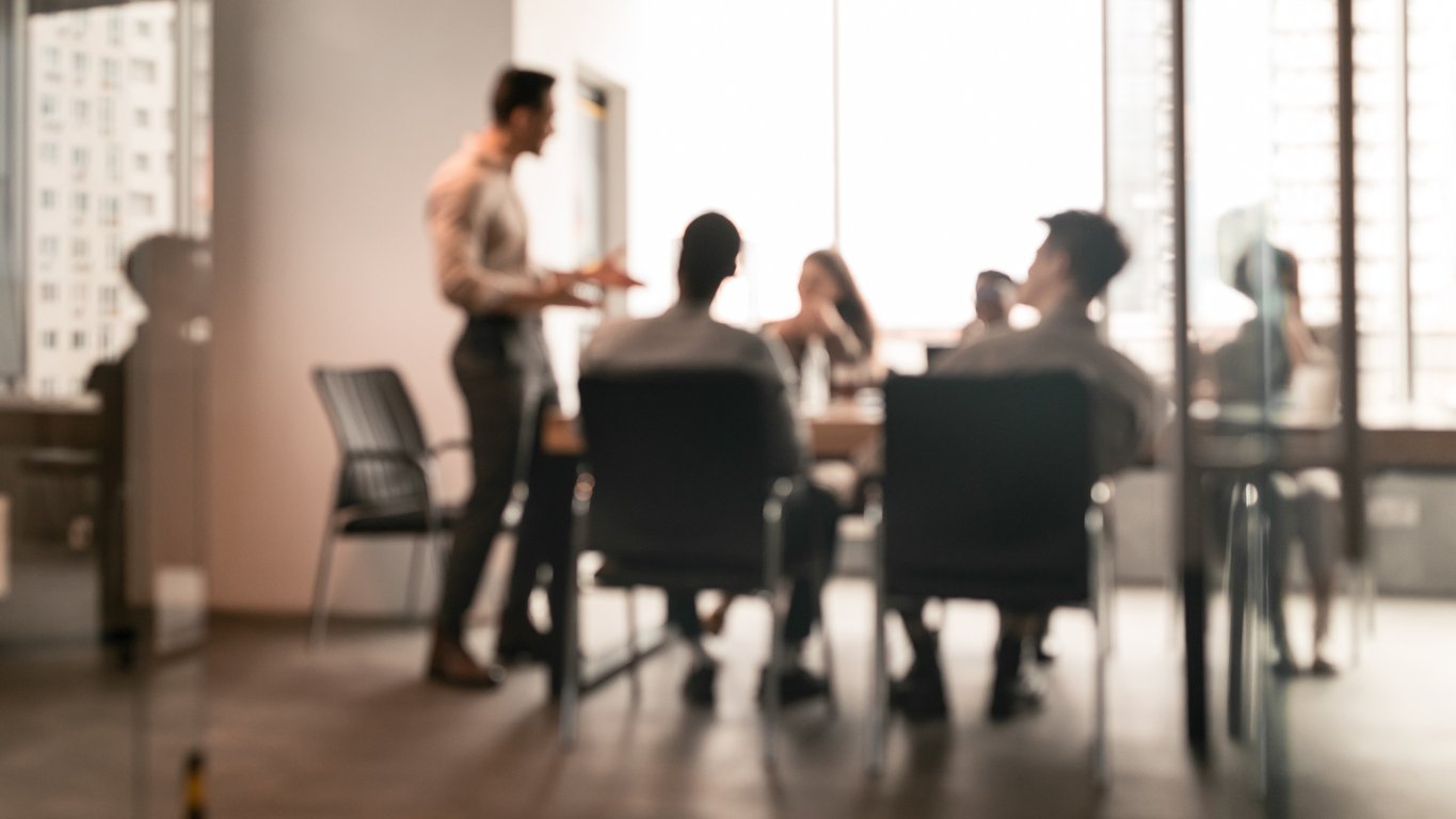 colleagues meet in an office to discuss a tense situation